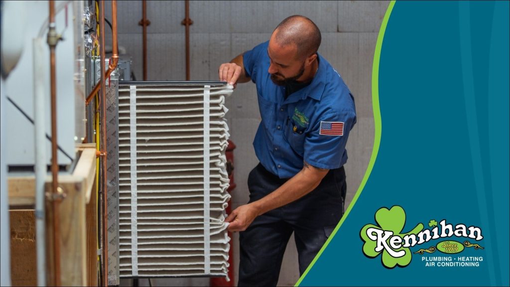 A Kennihan HVAC tech changing an air filter.